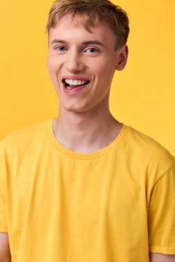 Sarı tişörtlü mutlu bir adam, pozitif duygu, rahatlama tarzı ve pazarlama, sosyal medya ve ürün vitrinleri için çok yönlü ışıklandırma sergiliyor.