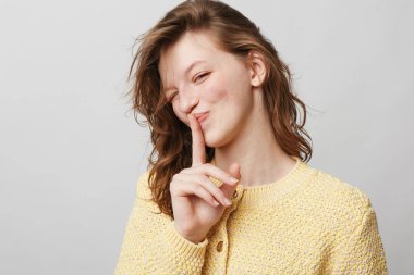 Sarı örgü süveter giyen gülümseyen genç bir kadın, 