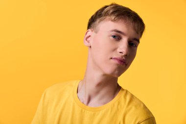 Genç adam, sarı arka plan, monokrom, gündelik moda, yaşam tarzı, model, iyimser, yakın çekim güven ve modern tarz pazarlama, editoryal kullanım, markalaşma