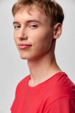 Genç adam, kırmızı gömlek, kendine güvenen, yakın çekim, stüdyo ışıklandırması, rahat duruş ve doğal ifade pazarlama, reklam veya promosyon malzemeleri için uygun.