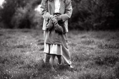 Anne ve kızı birlikte eğleniyor. Doğada haftasonu çimlerin arasında, ormanın yakınında