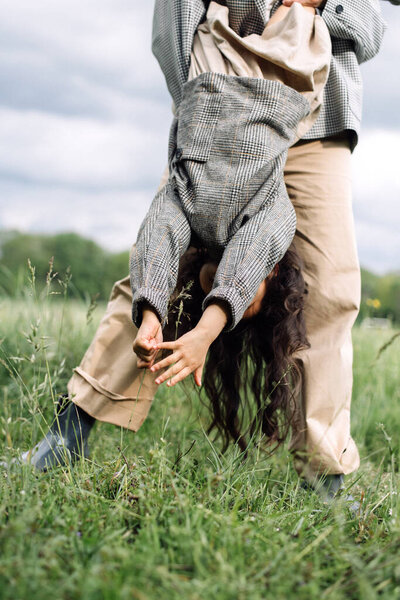 Mom and daughter have fun together. Weekend in nature near the forest in the grass