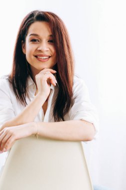 Evdeki sandalyede beyazlar içinde güzel bir esmerin portresi.