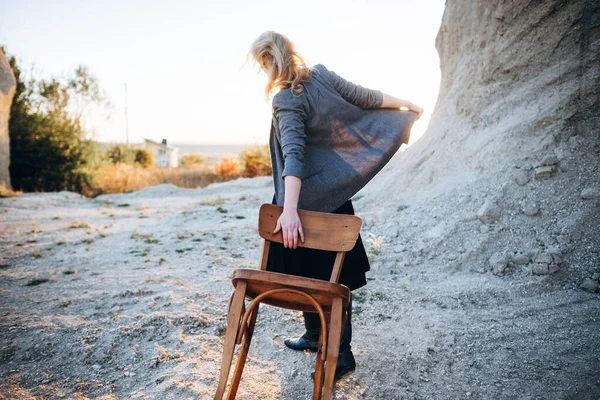 在西部 红头发的女孩拿着一把旧椅子走在沙地上 孤独的心理画像 希波斯特旧式时尚概念 — 图库照片