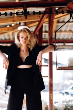 Kırmızı saçlı bir kızın portresi. Siyah retro taşra kıyafetleri giymiş. 