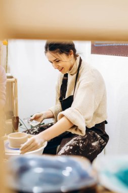 Anne ve kızlarının çanak çömlek üretme süreci. Çömlek atölyesinde çalışan kadın eller..