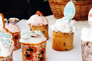 Kurabiye, bize ve çiçeklerle süslenmiş Paskalya pastaları. Beyaz arka planda süslemeleri olan ev yapımı Paskalya pastası.