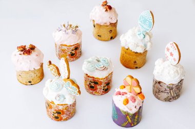 Kurabiye, bize ve çiçeklerle süslenmiş Paskalya pastaları. Beyaz arka planda süslemeleri olan ev yapımı Paskalya pastası.