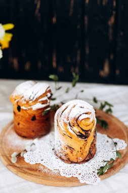Kuru üzümlü, haşhaş tohumlu ve tahta tabakta pudra şekerli ev yapımı Paskalya pastası.