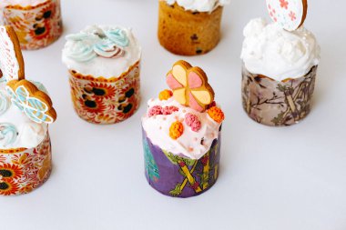 Kurabiye, bize ve çiçeklerle süslenmiş Paskalya pastaları. Beyaz arka planda süslemeleri olan ev yapımı Paskalya pastası.