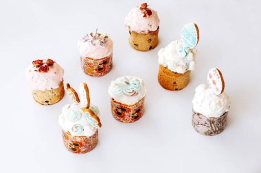 Kurabiye, bize ve çiçeklerle süslenmiş Paskalya pastaları. Beyaz arka planda süslemeleri olan ev yapımı Paskalya pastası.