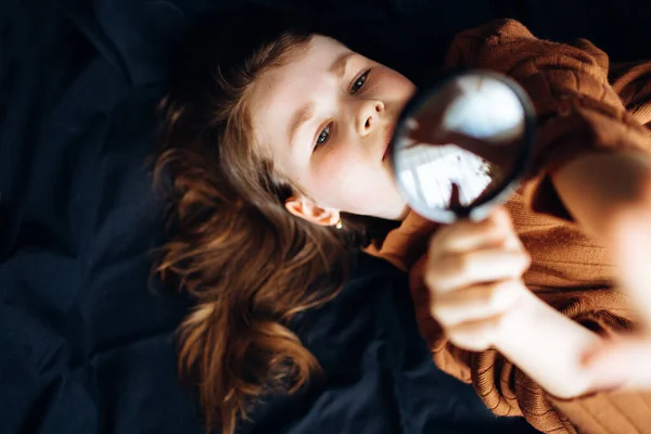 Cute Girl Looks Magnifying Glass While Lying Dark Background Royalty Free Stock Images