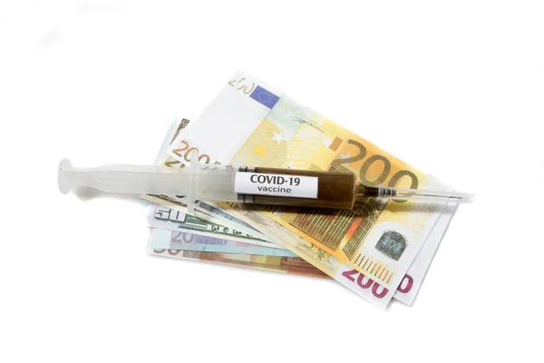 Vista ravvicinata dell'ago su una siringa riempita di vaccino posta su una banconota in euro — Foto Stock