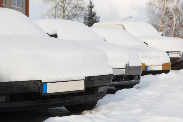 Снігові покриті автомобілі припарковані в ряд поруч один з одним . — стокове фото