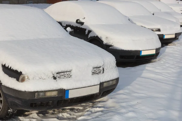 Zasněžená auta zaparkovaná v řadě vedle sebe. — Stock fotografie