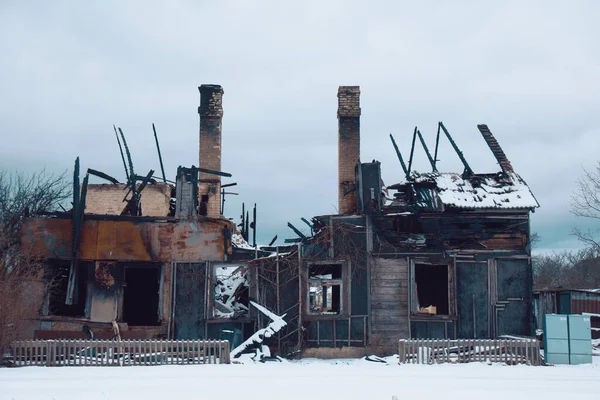 Abgebranntes Holzhaus. Haus nach dem Brand. Gebranntes Backsteinhaus mit abgebranntem Dach lizenzfreie Stockfotos