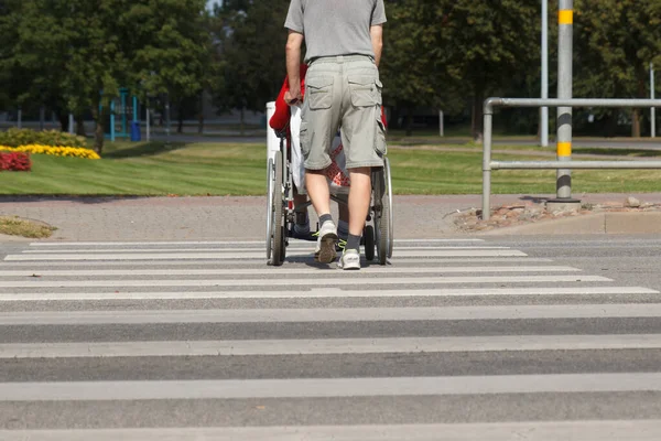 A man pushes wheelchair with disabled — Stock Photo, Image