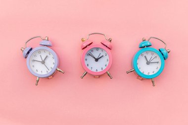 Pembe pastel arka planda izole edilmiş, çalan üç adet klasik alarm saati. Hayatın dinlenme saatleri. İyi sabahlar. Uyanık kalma kavramı. Düz görünüm kopyalama alanı