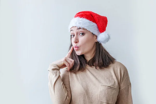 戴着红色圣诞老人帽的漂亮姑娘被白色背景隔离了 年轻女子的冬季肖像 圣诞和新年快乐假期的概念 — 图库照片