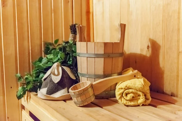 Interior details Finnish sauna steam room with traditional sauna accessories basin birch broom scoop felt hat towel. Traditional old Russian bathhouse SPA Concept. Relax country village bath concept