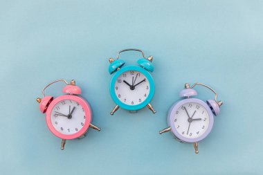 En az tasarım üç zil çalan klasik alarm saati mavi pastel arka planda izole edildi. Hayatın dinlenme saatleri. İyi sabahlar. Uyanık kalma kavramı. Düz görünüm kopyalama alanı