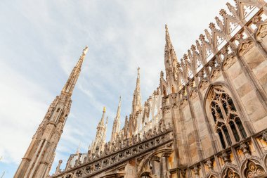 Milano Katedrali Duomo di Milano 'nun çatısında Gotik kuleler ve beyaz mermer heykeller var. Milano, Lombardia, İtalya 'daki bir numaralı turistik ilgi merkezi. Eski Gotik mimari ve sanatın geniş açı görüntüsü