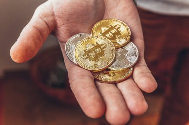 Şifreli altın ve gümüş bitcoin parayı tutan adam. İnternet bankacılığı ve uluslararası ağ ödemeleri için elektronik sanal para. Şifreli sanal para biriminin sembolü. Madencilik kavramı