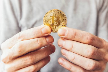 Şifreli altın bitcoin parayı tutan adam. İnternet bankacılığı ve uluslararası ağ ödemeleri için elektronik sanal para. Şifreli sanal para biriminin sembolü. Madencilik kavramı
