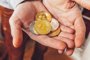 Şifreli altın ve gümüş bitcoin parayı tutan adam. İnternet bankacılığı ve uluslararası ağ ödemeleri için elektronik sanal para. Şifreli sanal para biriminin sembolü. Madencilik kavramı