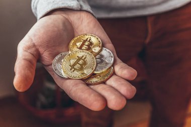 Şifreli altın ve gümüş bitcoin parayı tutan adam. İnternet bankacılığı ve uluslararası ağ ödemeleri için elektronik sanal para. Şifreli sanal para biriminin sembolü. Madencilik kavramı