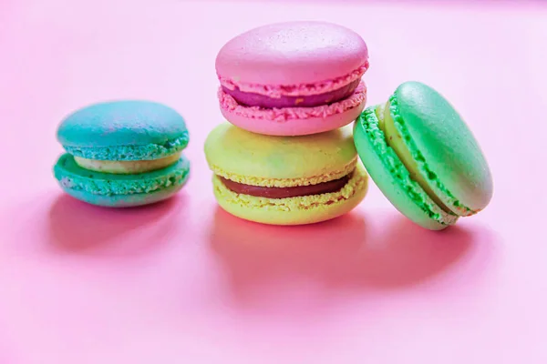 Doce amêndoa rosa colorido azul amarelo macaron verde ou bolo de sobremesa macaroon isolado no fundo pastel rosa na moda. Biscoito doce francês. Conceito mínimo de padaria de alimentos. Flat lay vista superior, espaço de cópia — Fotografia de Stock