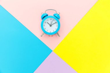 Çalan ikiz çan klasik alarm saati mavi pembe renkli renkli geometrik arkaplanda izole edilmiş. Hayatın dinlenme saatleri. İyi sabahlar. Uyanık kalma kavramı. Düz görünüm kopyalama alanı