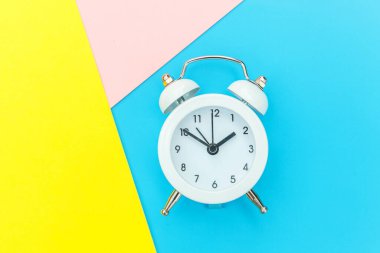 Çalan ikiz çan klasik alarm saati mavi pembe renkli renkli geometrik arkaplanda izole edilmiş. Hayatın dinlenme saatleri. İyi sabahlar. Uyanık kalma kavramı. Düz görünüm kopyalama alanı