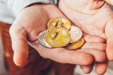 Şifreli altın ve gümüş bitcoin parayı tutan adam. İnternet bankacılığı ve uluslararası ağ ödemeleri için elektronik sanal para. Şifreli sanal para biriminin sembolü. Madencilik kavramı