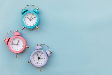 En az tasarım üç zil çalan klasik alarm saati mavi pastel arka planda izole edildi. Hayatın dinlenme saatleri. İyi sabahlar. Uyanık kalma kavramı. Düz görünüm kopyalama alanı