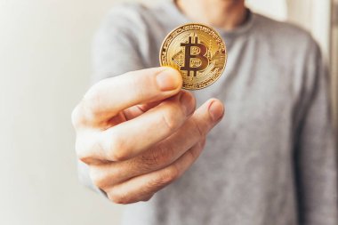 Şifreli altın bitcoin parayı tutan adam. İnternet bankacılığı ve uluslararası ağ ödemeleri için elektronik sanal para. Şifreli sanal para biriminin sembolü. Madencilik kavramı