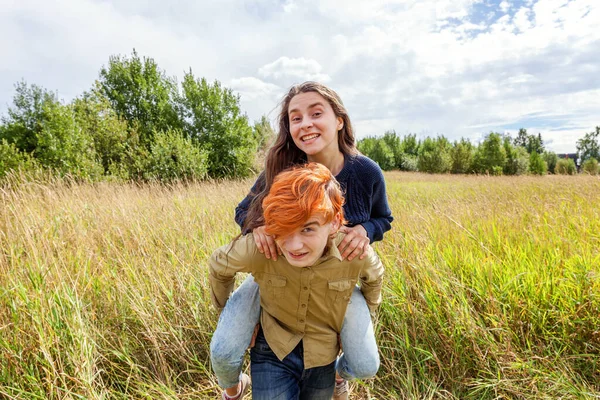 Summer holidays vacation happy people concept. Loving couple having fun in nature outdoors. Happy young man piggybacking his girlfriend. Happy loving couple embracing outdoor at summertime
