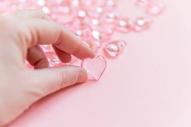 Sevgililer Günü konsepti. Pembe renkli arka planda pembe kalbi tutan kadın. Sevgililer gününde kartpostal afişi. Aşk kaçamağı aşk evliliği aşk sembolü. Üst görünüm düzlüğü