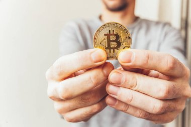 Şifreli altın bitcoin parayı tutan adam. İnternet bankacılığı ve uluslararası ağ ödemeleri için elektronik sanal para. Şifreli sanal para biriminin sembolü. Madencilik kavramı