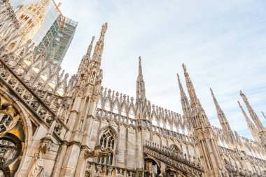 Milano Katedrali Duomo di Milano 'nun çatısında Gotik kuleler ve beyaz mermer heykeller var. Milano, Lombardia, İtalya 'daki bir numaralı turistik ilgi merkezi. Eski Gotik mimari ve sanatın geniş açı görüntüsü