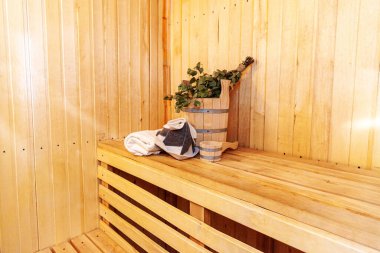 İçişleri, geleneksel sauna aksesuarları, süpürge kepçesi kepçeli şapka havlusuyla Finlandiya sauna sauna saunası detaylarını anlatıyor. Geleneksel eski Rus hamamı SPA konsepti. Rahatlayın köy banyosu konsepti