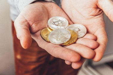 Şifreli altın ve gümüş bitcoin parayı tutan adam. İnternet bankacılığı ve uluslararası ağ ödemeleri için elektronik sanal para. Şifreli sanal para biriminin sembolü. Madencilik kavramı