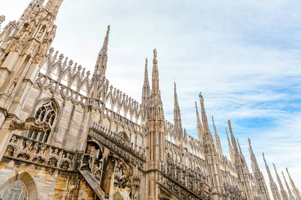 Milano Katedrali Duomo di Milano 'nun çatısında Gotik kuleler ve beyaz mermer heykeller var. Milano, Lombardia, İtalya 'daki bir numaralı turistik ilgi merkezi. Eski Gotik mimari ve sanatın geniş açı görüntüsü