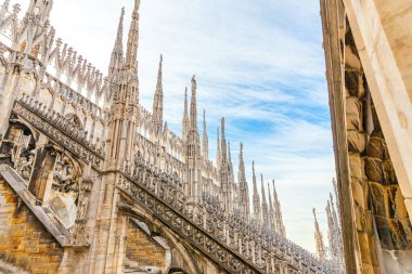 Milano Katedrali Duomo di Milano 'nun çatısında Gotik kuleler ve beyaz mermer heykeller var. Milano, Lombardia, İtalya 'daki bir numaralı turistik ilgi merkezi. Eski Gotik mimari ve sanatın geniş açı görüntüsü