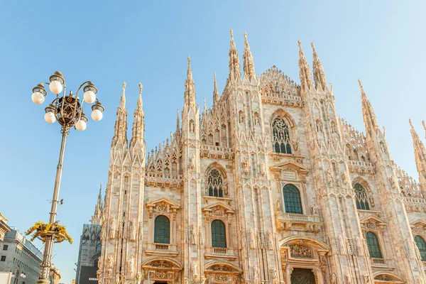 Famous church Milan Cathedral Duomo di Milano with Gothic spires and white marble statues. Top tourist attraction on piazza in Milan Lombardia Italy Wide angle view of old Gothic architecture and art