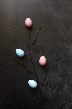 Mutlu Paskalyalar. Tatil için hazırlık. Modayı takip eden grunge üzerindeki renkli paskalya yumurtaları koyu siyah taş arkaplanı çizmiş. Basit minimalizm düz üst görünüm kopyalama alanı