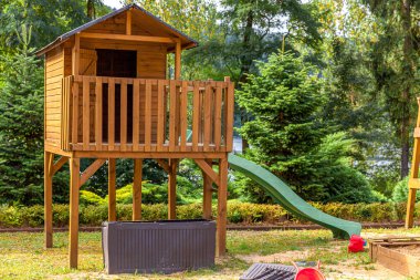 Yazın parktaki yeşil bahçeye kurulmuş boş, modern ahşap çocuk oyun parkı. Çocuklar için komik bir yer. Çocuklar için şehir içi spor aktiviteleri. Mahallenin çocukluk kavramı