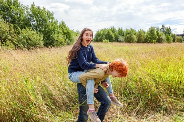 Summer holidays vacation happy people concept. Loving couple having fun in nature outdoors. Happy young man piggybacking his girlfriend. Happy loving couple embracing outdoor at summertime