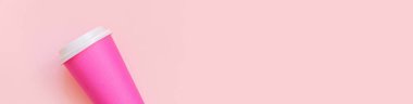 Pembe pastel renkli arka planda düz dizayn pembe kağıt kahve fincanı. Paket içecek konteynırı. Günaydın uyanık kavramı. İçkinin şablonu. Üst görünüm kopyalama alanı afişi