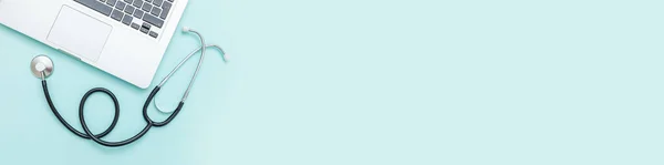 Stetoskop klavye dizüstü bilgisayarı mavi arkaplanda izole edilmiş. Modern tıbbi bilgi teknolojisi, yazılımlar konsepti geliştirir. Bilgisayar ve cihaz kontrolü ve onarımı. Düz görünüm pankartı yatıyordu
